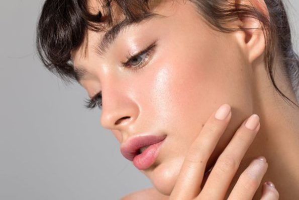 Model with dewy skin and a radiant glow – representing the glass skin makeup trend.