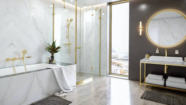 Elegant bathroom accessories including plush towels, matching dispensers, and gold fixtures for a luxurious touch